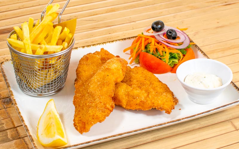 PalmBeach Tropical Restaurant | Chicken breast with Crunchy pepper flavored Breading | served with mixed salad and french fries accompanied by a sauce made with mayonnaise, garlic and parsley