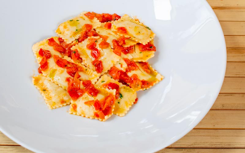 PalmBeach Tropical Restaurant | Fish Ravioli | artisanal fresh pasta ravioli filled with fish, potato cream, and vegetables, topped with fresh tomato cubes