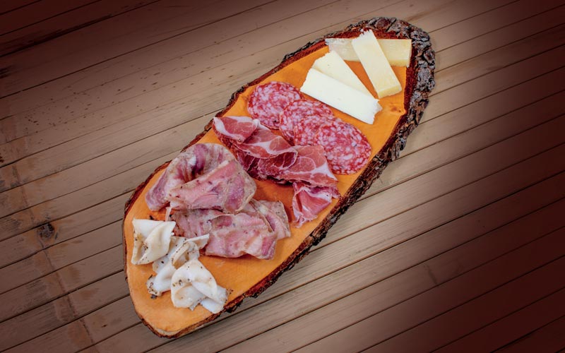 PalmBeach Tropical Restaurant | The Tuscan Cutting Board | To fully appreciate the flavors of this Tuscan Delicacies Board, we recommend following a specific tasting order. A crescendo of intensity, from the freshest and most delicate to the most intense and aged. The only way to truly appreciate the characteristics of each individual product.<br>
<strong>1. Flavored Lard</strong> fatty and delicate product, with a very soft flavor and texture<br>
<strong>2. Fibrous Head Cheek</strong> velvety-smooth cured meat with a complex and satisfying taste<br>
<strong>3. Aged Capocollo</strong> more aged cured meat, with an even more intense flavor and aroma<br>
<strong>4. Truffle Salami</strong> truffle-flavored salami, to fully appreciate the persistence of its strong aromas<br>
<strong>5. Pienza Black Sheep’s Cheese</strong> sheep’s cheese, with a medium aging and not too intense flavor<br>
<strong>6. Cave-Aged Sheep’s Cheese</strong> aged sheep’s cheese with an intense flavor and complex taste