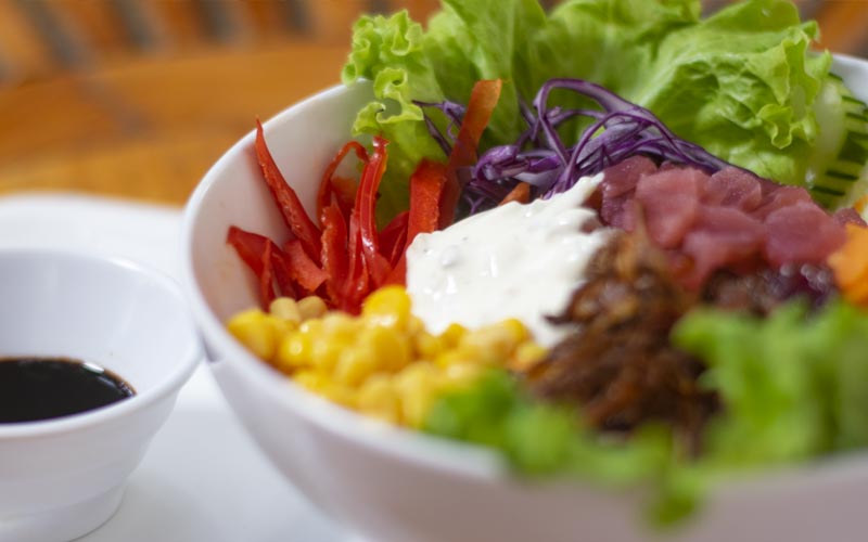 PalmBeach Tropical Restaurant | Tuna and Rice Poke | bowl of rice with raw tuna, corn, cucumbers, green salad, purple cabbage, fried onions, sesame seeds, garlic mayonnaise and served with soy sauce on the side